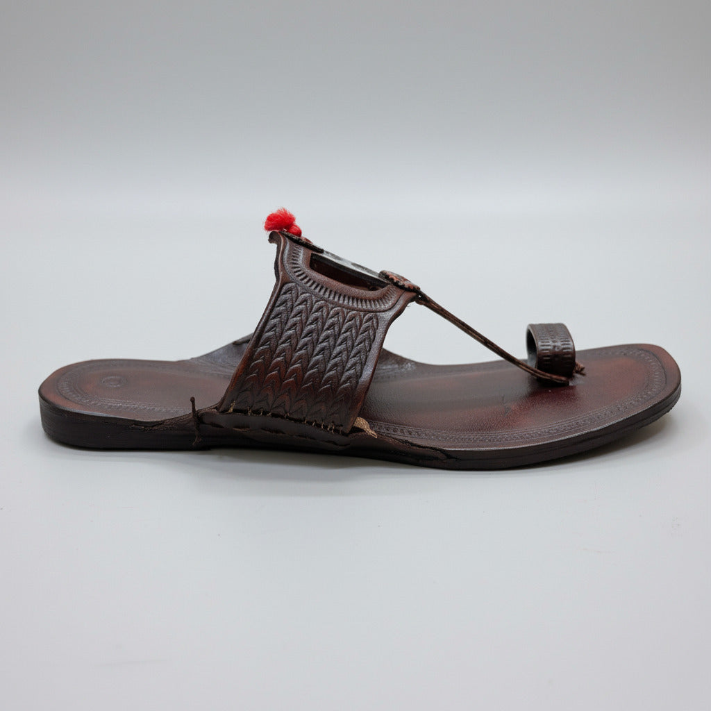 Brown sandal with a decorative strap on a light-colored floor
