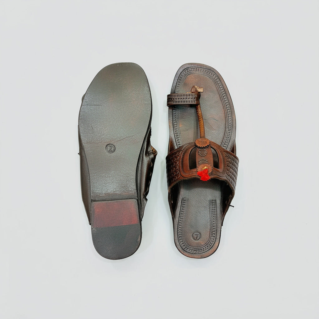 Brown leather sandal with a strap on a beige textured background