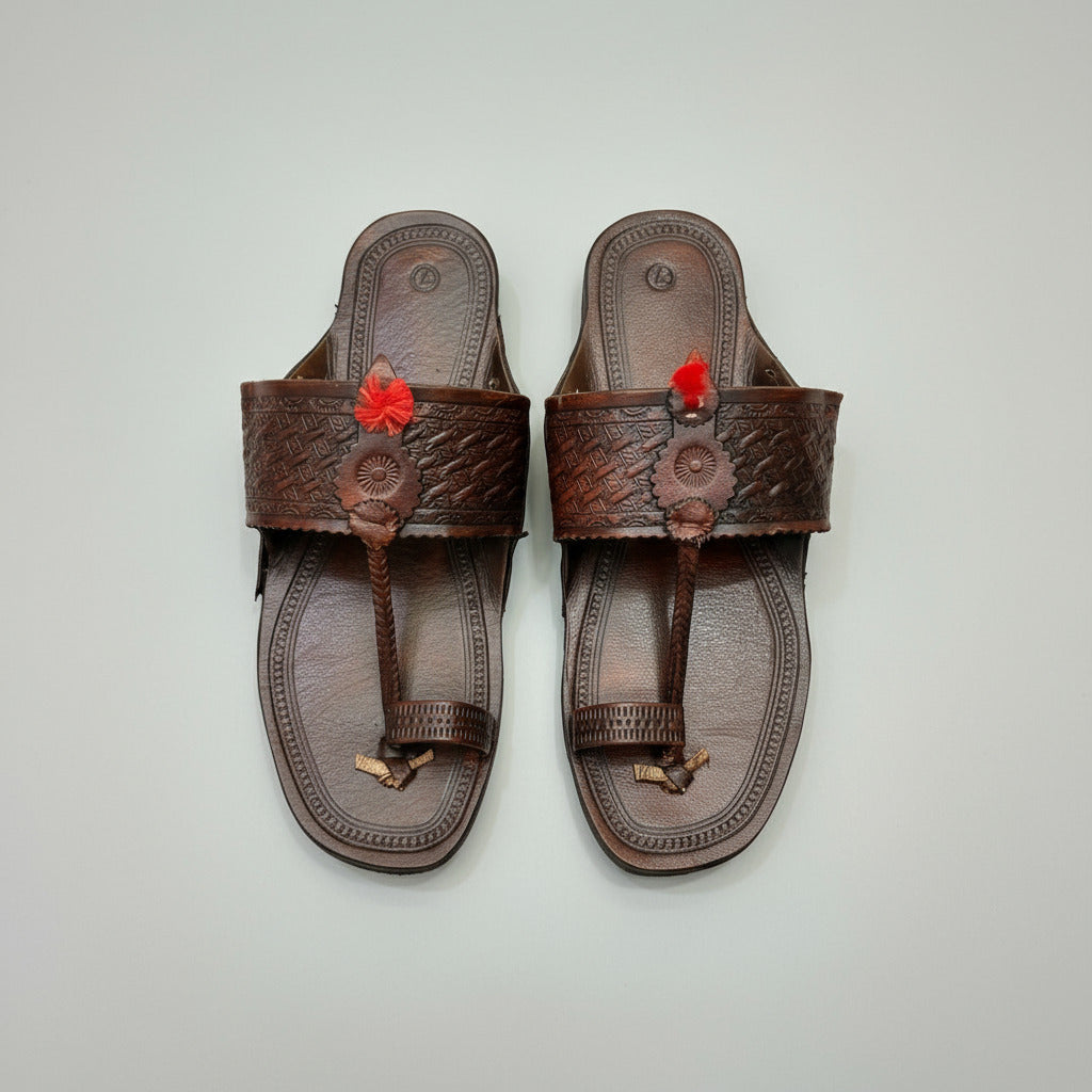 Pair of brown sandals with decorative straps on a beige textured background