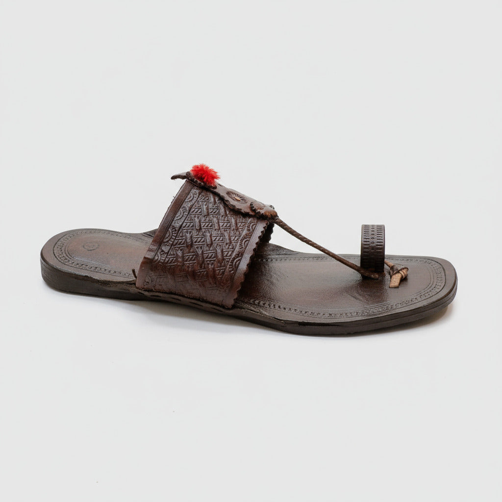 Brown sandal with decorative elements on a light-colored tiled floor