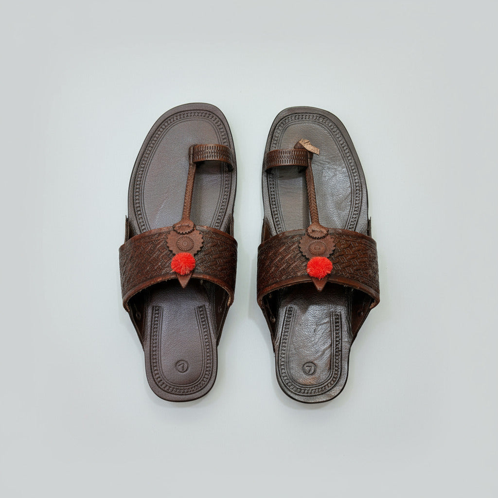 Brown sandal with a decorative strap on a beige textured background