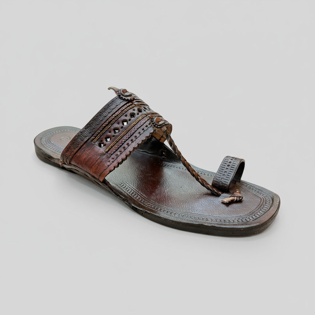 Brown sandal with decorative straps on a light-colored floor