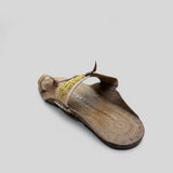 Brown sandal with a strap on a light-colored floor