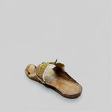 Single sandal on a textured floor with a blurred background