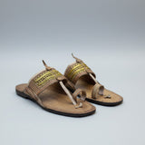 Pair of traditional sandals with decorative straps on a light background