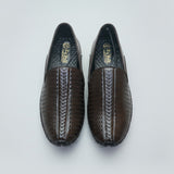 Pair of brown leather shoes with a textured pattern on a light beige surface.