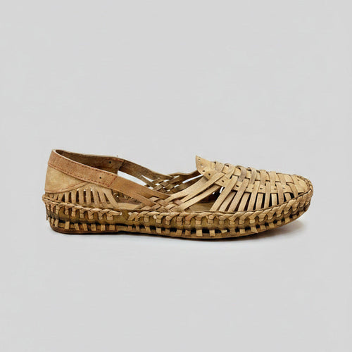 Woven sandal on a cracked concrete floor