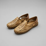 Pair of woven sandals on a light marble floor