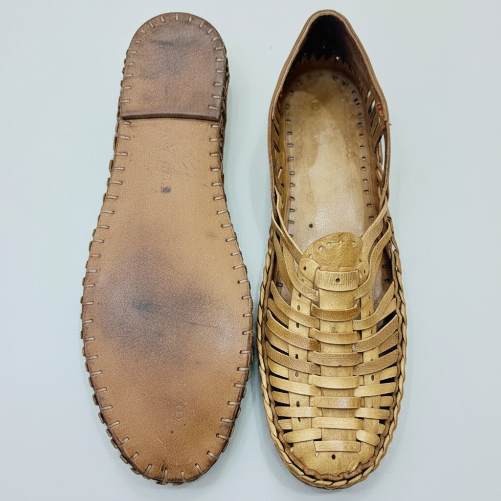 Pair of leather kolhapuri clogs on a textured surface
