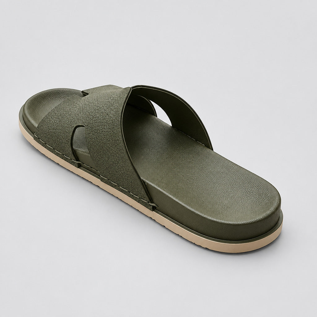 A single olive green slide sandal with a textured upper and a beige outsole, photographed on a polished beige marble floor.